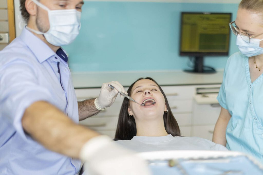 Zahnarzt Stegherr und eine Assistentin bei der Behandlung einer Patientin. 